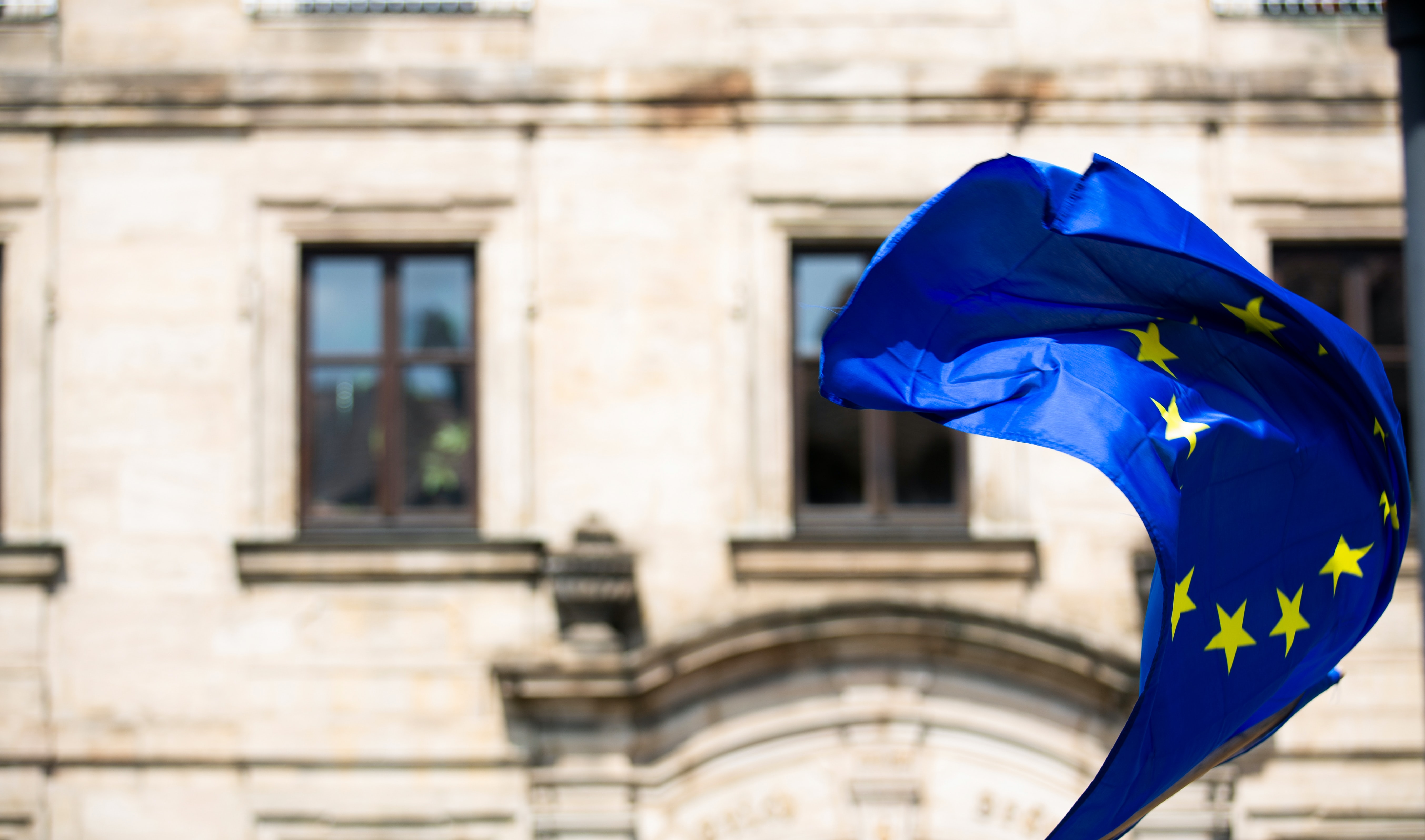 european union flag waving in front of building