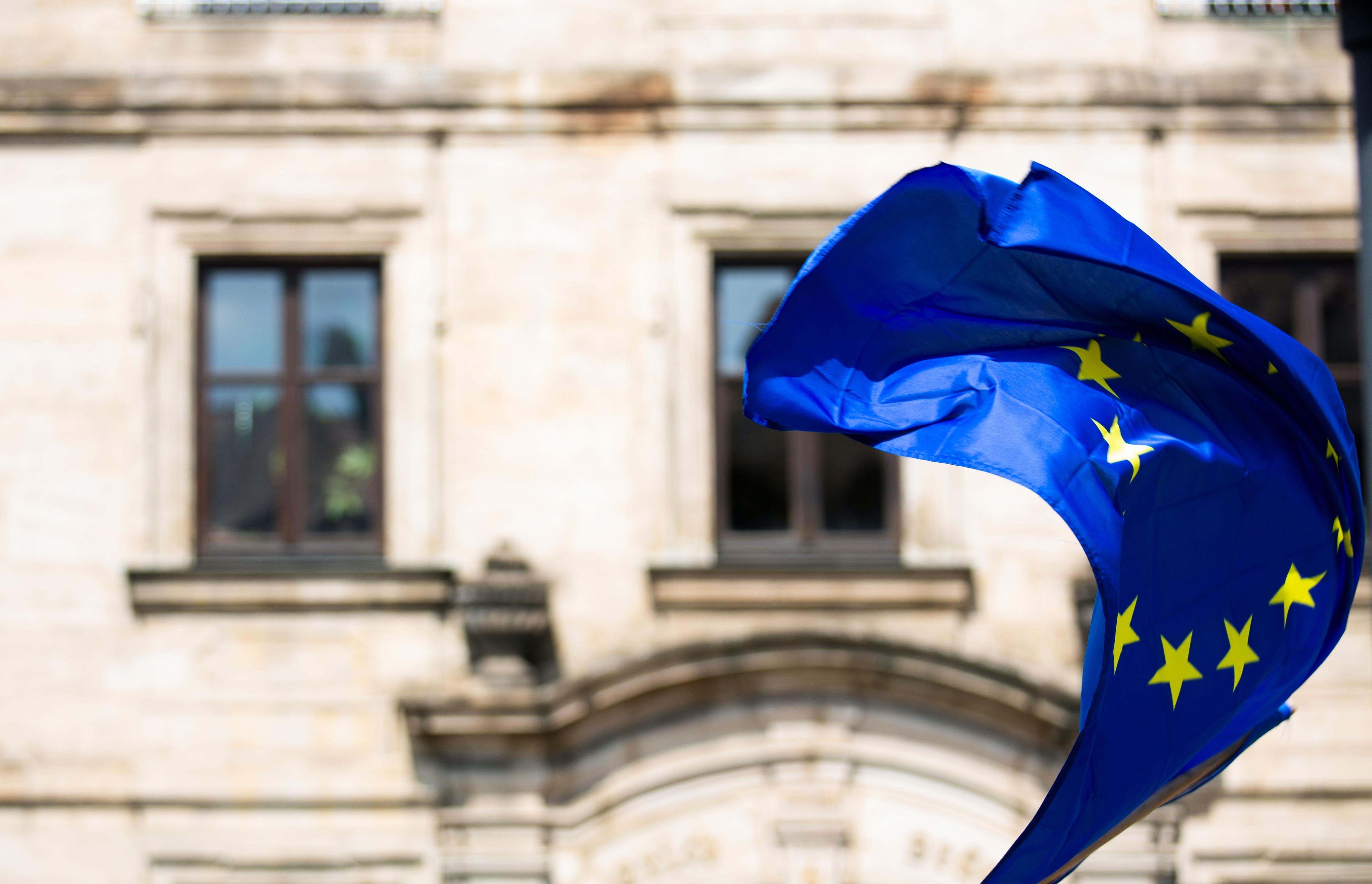 european union flag waving in front of building